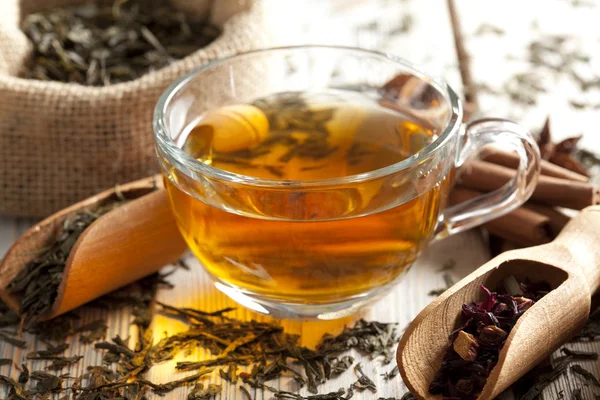 Xícara de chá e mistura de folhas de chá sortidas na mesa de madeira — Fotografia de Stock