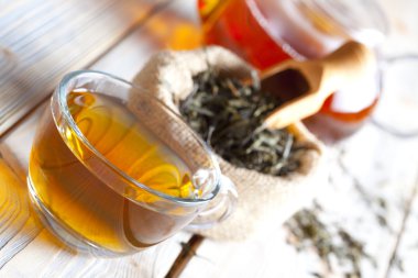 Bardak çay, çay yaprakları ve çaydanlık ahşap tablo