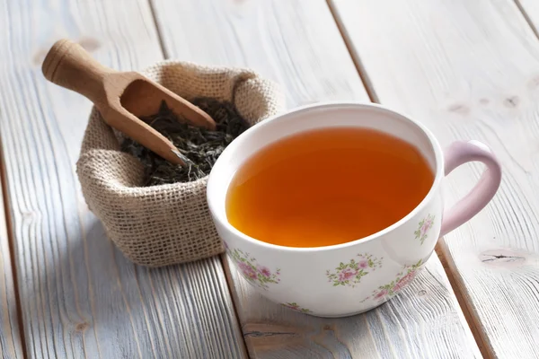 Cup of tea and dried tea leaves — Stock Photo, Image