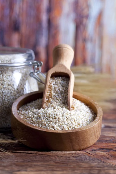 Buckwheat in bowl and jar on wooden table — Stock Photo, Image