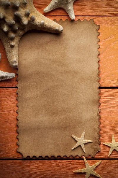 Etiqueta de papel e estrela do mar em fundo de madeira — Fotografia de Stock