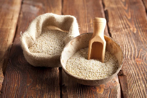 Buckwheat in wooden bowl and bag — Stock Photo, Image