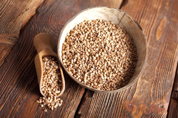 Grano saraceno in misurino e ciotola sul tavolo di legno — Foto Stock