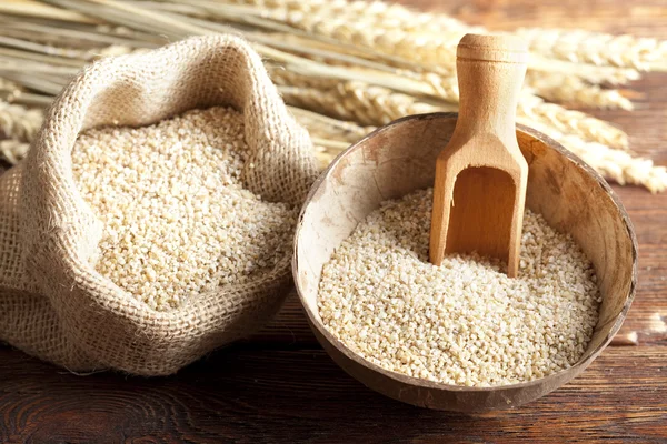 Buckwheat in wooden bowl and bag — Stock Photo, Image