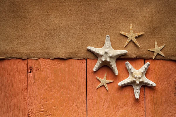 Folha de papel artesanal e estrela do mar em tábuas de madeira — Fotografia de Stock