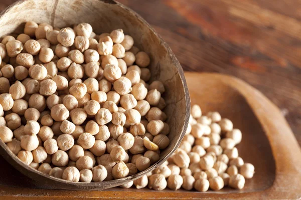 Chickpeas in bowl on wooden table — Stock Photo, Image