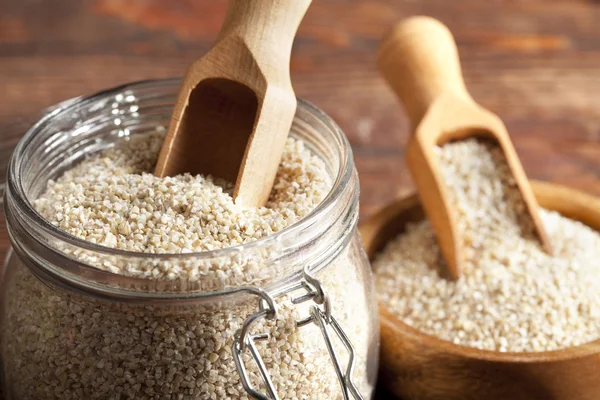 Buckwheat in a jar and wooden bowl — Stock Photo, Image