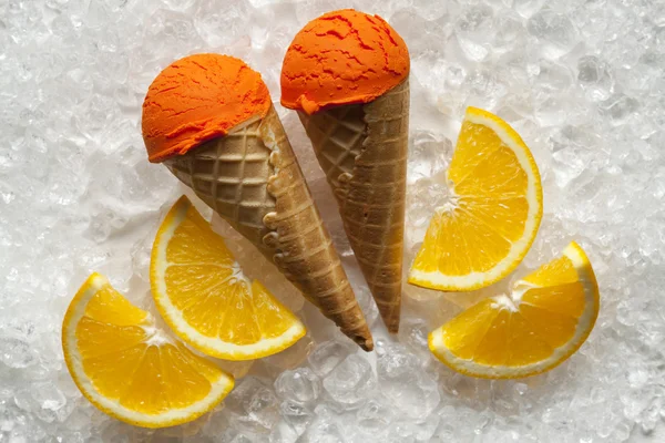Мороженое, конусные и апельсиновые ломтики на кубиках льда — стоковое фото