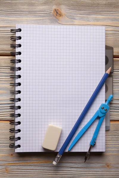 Bloco de notas, lápis, paquímetro e borracha sobre fundo de madeira — Fotografia de Stock
