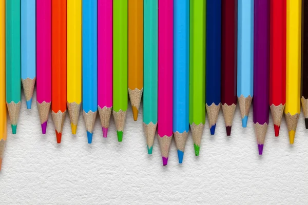 Lápis coloridos sobre fundo de papel — Fotografia de Stock