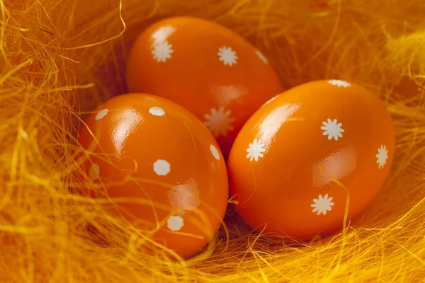 Tre uova di Pasqua arancioni nel nido — Foto Stock