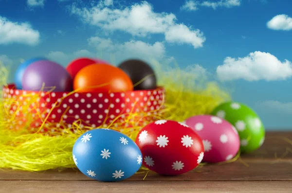 Colored Easter eggs on the grass and blue sky background — Stock Photo, Image