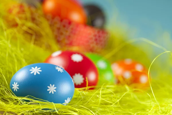 Colored Easter eggs on the grass and blue sky background — Stock Photo, Image