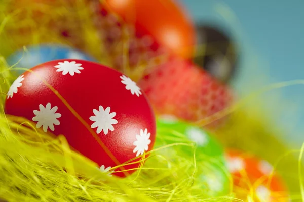 Huevos de Pascua de colores sobre la hierba y el fondo azul del cielo —  Fotos de Stock
