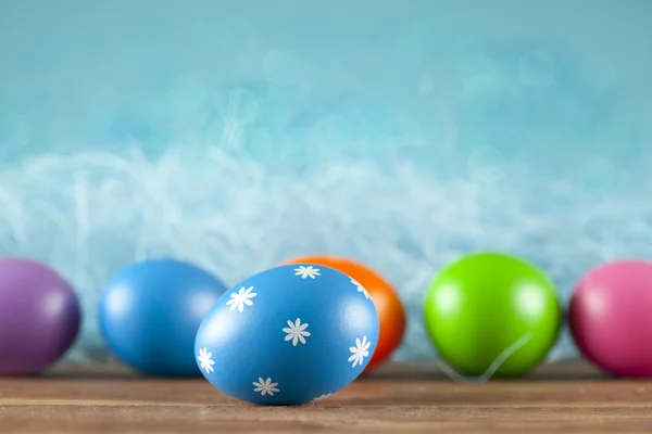 Ovos de páscoa coloridos sobre fundo azul — Fotografia de Stock