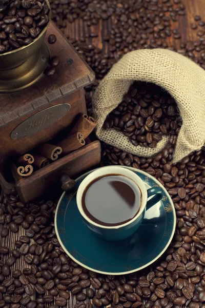 Cup of coffee, coffee beans and old grinder — Stock Photo, Image