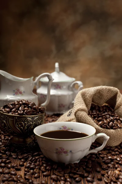 Xícara de café, feijão e saco de lona — Fotografia de Stock