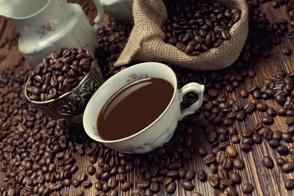 Xícara de café, feijão e saco de lona — Fotografia de Stock