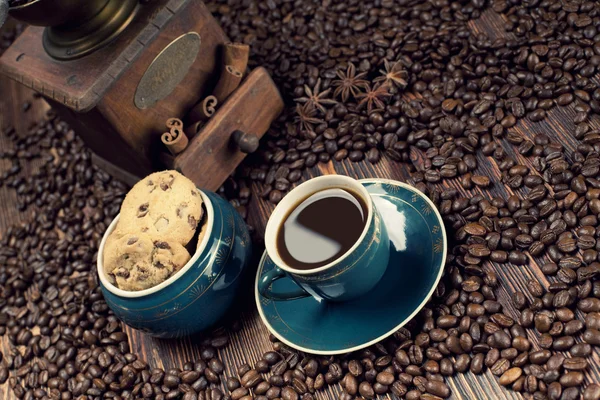 Coffee cup and coffee grains on old planks — Stock Photo, Image