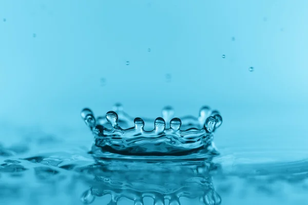 Éclaboussure d'eau sur fond bleu — Photo