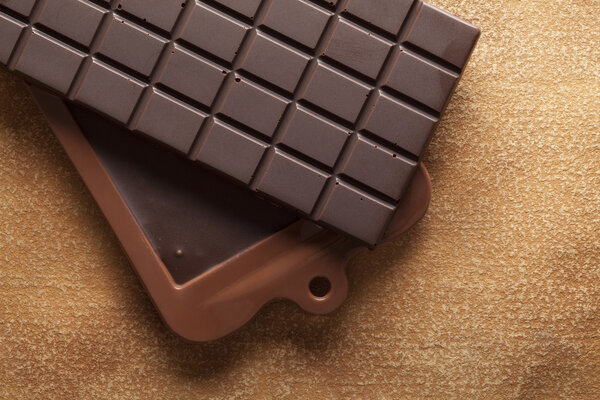 Домашний темный шоколад на бумажном фоне

