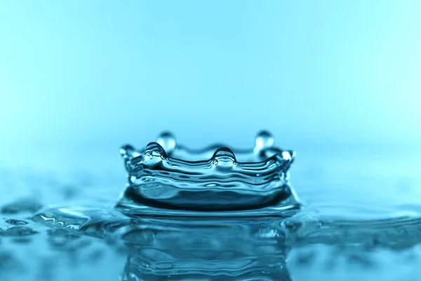 Éclaboussure d'eau sur fond bleu — Photo