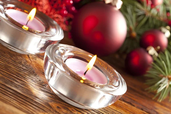 Candles and christmas decorations on branch of spruce tree — Stock Photo, Image