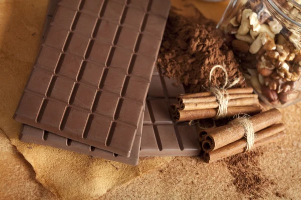 Barras de chocolate, cacau, paus de canela e nozes — Fotografia de Stock
