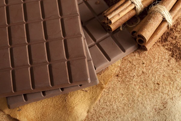 Barras de chocolate e paus de canela — Fotografia de Stock