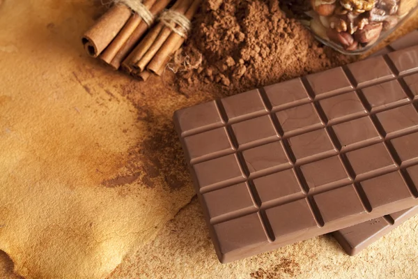 Barras de chocolate, palitos de canela, cacao y nueces —  Fotos de Stock