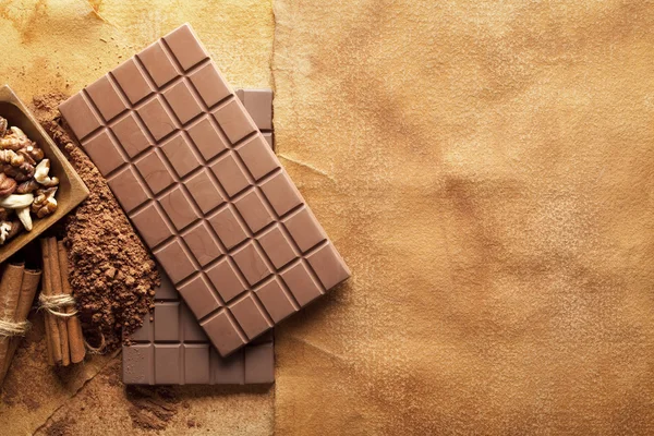 Barras de chocolate e ingredientes de chocolate sobre fondo de papel —  Fotos de Stock