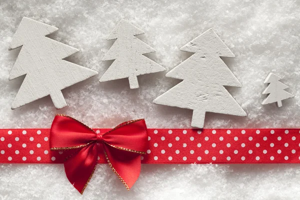 Drewniane drzewek na Boże Narodzenie, czerwony dziób i wstążki na śniegu — Zdjęcie stockowe