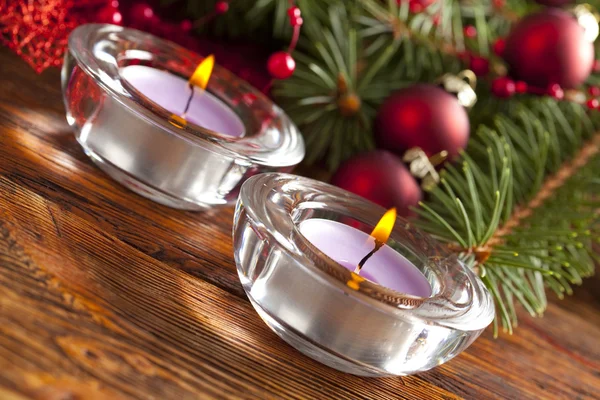 Candles and christmas decorations on branch of spruce tree Stock Picture