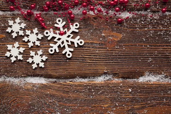 Flocos de neve brancos no fundo da parede de madeira — Fotografia de Stock