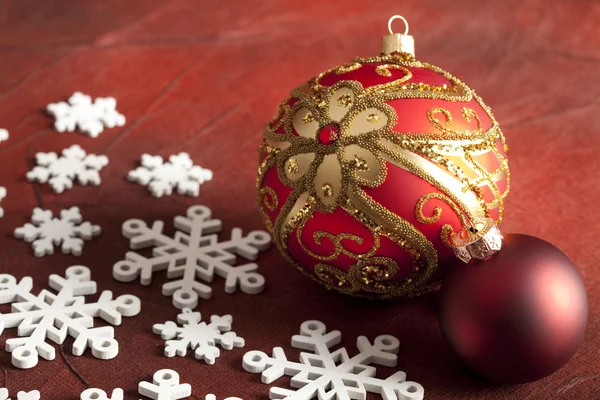 Natal bugigangas e flocos de neve no fundo vermelho — Fotografia de Stock