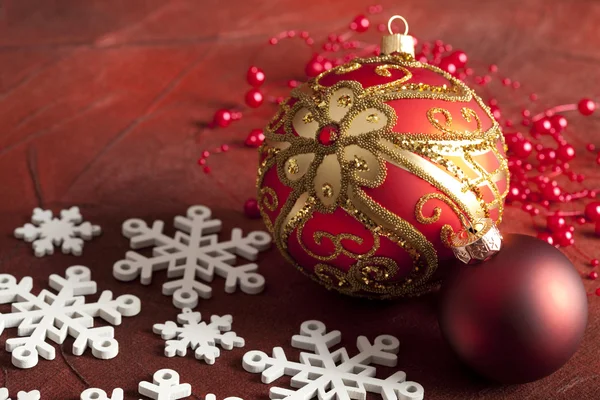 Boules de Noël et flocons de neige sur fond rouge — Photo