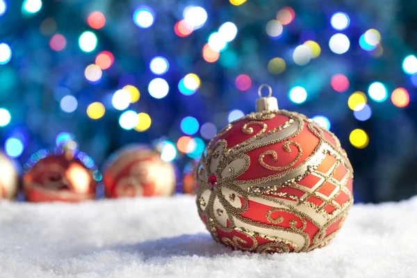 Rosso Natale bagattelle sulla neve e illuminazione di sfondo — Foto Stock