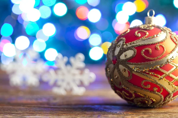 Natal bugiganga e flocos de neve no fundo de iluminação — Fotografia de Stock