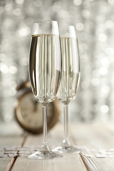 香槟和闹钟木制背景上的眼镜 — 图库照片