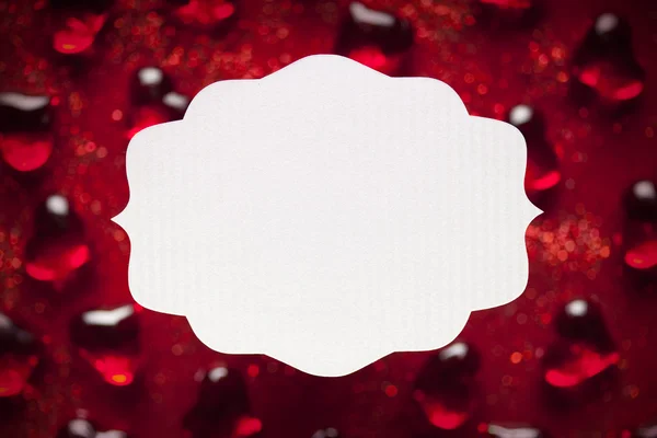 Blank label and red hearts in background — Stock Photo, Image