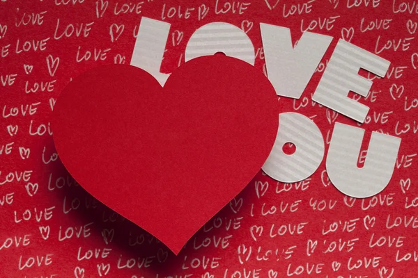 Kırmızı arka plan üzerinde kalp ve kağıt metin şeklinde — Stok fotoğraf