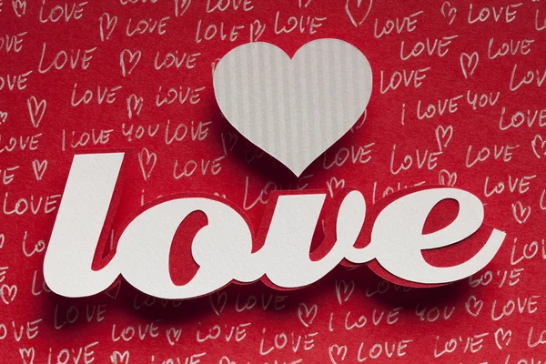 Любов - текст і форма серця на червоному тлі — стокове фото