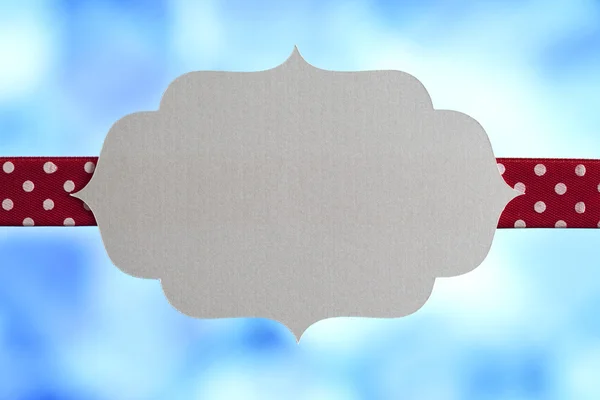 Blank label and ribbon on blue background — Stock Photo, Image