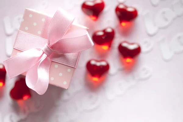 Red hearts and gift box on pink background — Stock Photo, Image