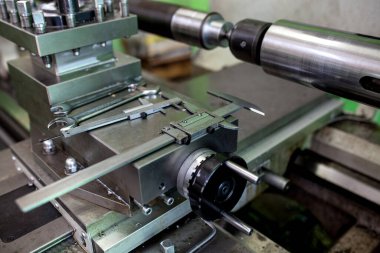 Profesyonel işçiler metal parçaları, büyük endüstriyel fabrika imajındaki metal makineleri için değirmen işlemini yapıyor.