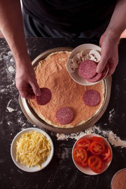 Yemek konsepti. Taze, orijinal İtalyan çiğ pizzası, geleneksel tarzda hazırlanma. Evde pizza yapmak. Gerçek bir evde pizza pişirmek.