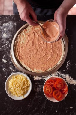 Yemek konsepti. Taze, orijinal İtalyan çiğ pizzası, geleneksel tarzda hazırlanma. Evde pizza yapmak. Gerçek bir evde pizza pişirmek.