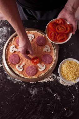 Yemek konsepti. Taze, orijinal İtalyan çiğ pizzası, geleneksel tarzda hazırlanma. Evde pizza yapmak. Gerçek bir evde pizza pişirmek.