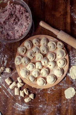 Ev yapımı mantı ya da masada etli ravioli pişirmek. Kadın eli köfte yapar. Geleneksel Rus köftesi..