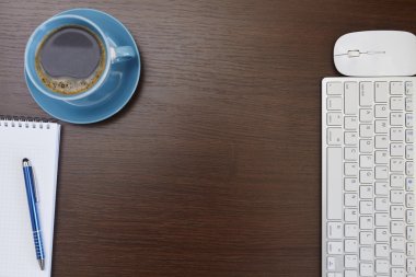 Ofis resepsiyon masası bilgisayar, sarf malzemeleri ve kahve fincanı ile